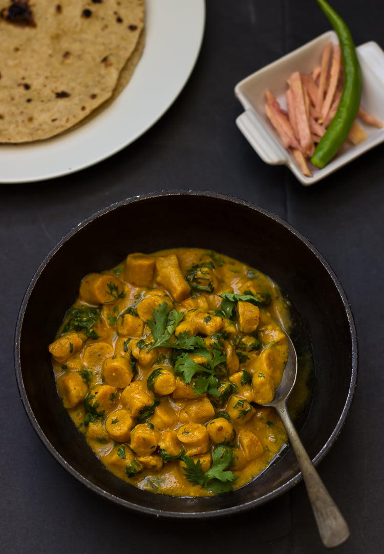 A bowl of Gatte Ki Sabji with a spoon ready to enjoy