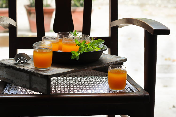 Pouring Bel Ka Sharbat from a jug into a glass, ready to be enjoyed