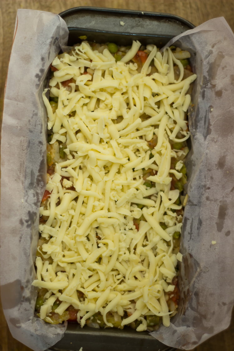 Vegetable loaf topped with the cheese, ready to bake