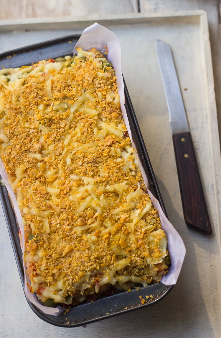 Freshly baked vegetable loaf in a baking tray, and a knife at the side