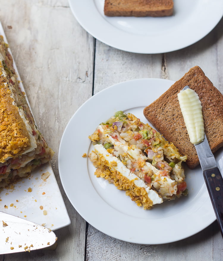 A slice of vegetable loaf with a spread of creamy cheese on top