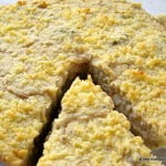 A slice of Eggless Caramelized Onion and Corn Quiche showcasing a golden, flaky crust and savory filling