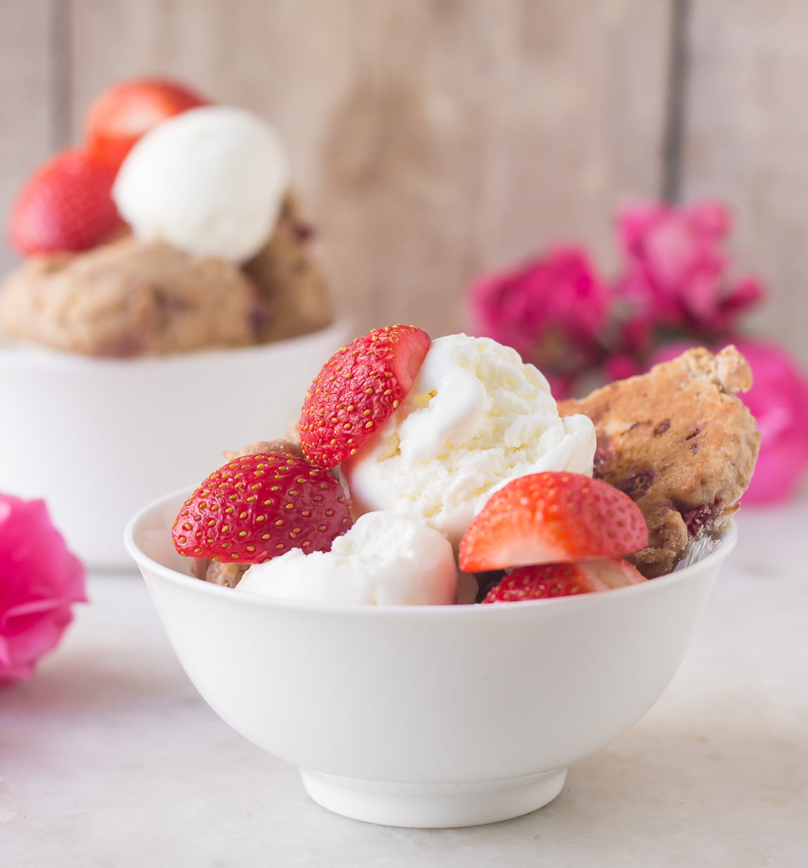 Scones served with a bowl of whipped cream and fresh strawberries