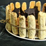 Eggless Tiramisu Charlotte decorated on a plate with a ribbon tied around it