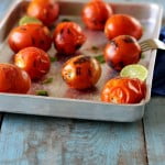 Top view of the blanched tomatoes in a tray with the slices of lemon