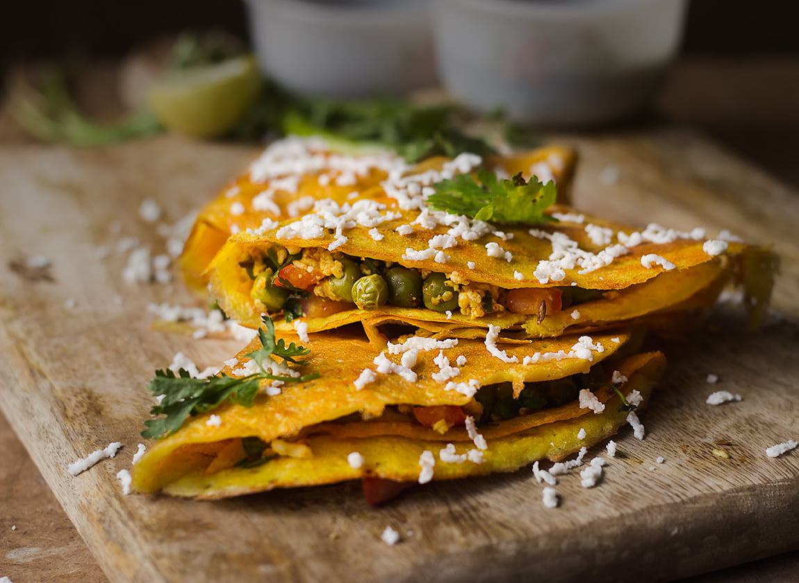 Close-up of a plate with moong dal chilla, garnished with coriander leaves