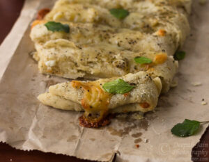 Homemade Dominos style cheesy breadsticks with a side of butter
