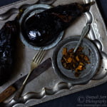 Charred and roasted eggplant cooling on a plate