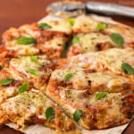 Sliced whole wheat Margherita pizza showing golden crust and melted cheese