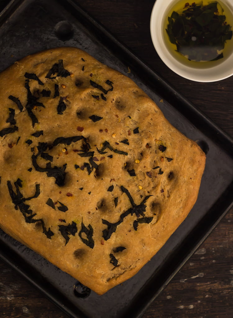 Golden whole wheat basil focaccia bread served with dipping oil