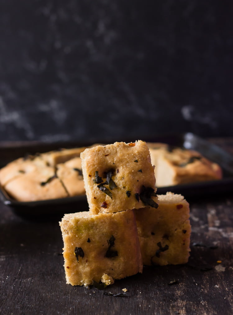 Slicing into freshly baked whole wheat basil focaccia bread

