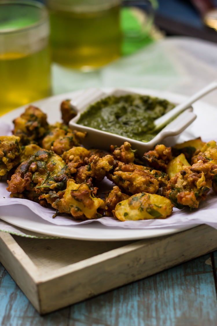 A plate of golden Aloo Bread Pakoris served with green chutney