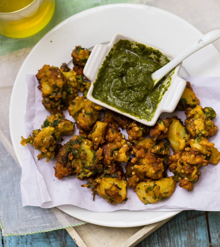 A plate of Aloo Bread Pakoris accompanied by a cup of hot tea, perfect for a snack