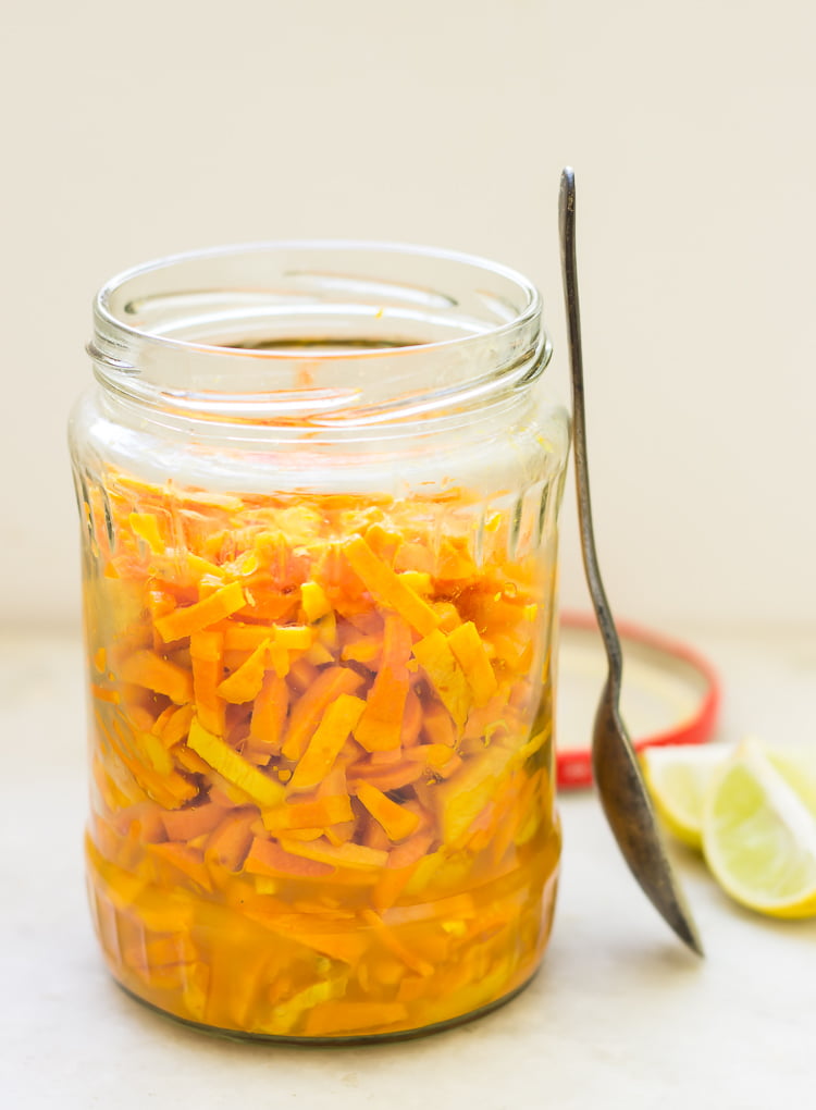 Jar of Kachi Haldi ka Achar placed with a spoon and a slice of lemon