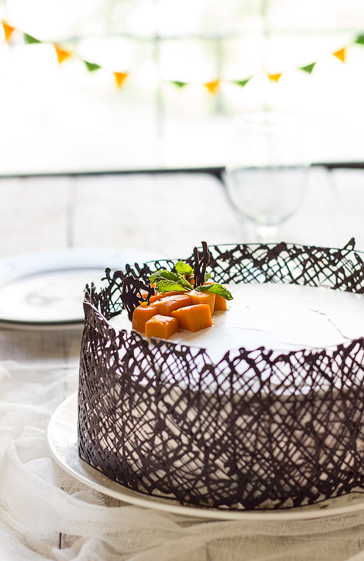 Eggless mango white cake topped with fresh mango slices and mint leaves