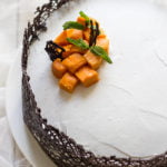 Eggless mango white cake topped with fresh mango slices and mint leaves