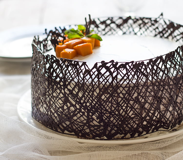 A beautifully presented eggless mango white cake on a dessert table