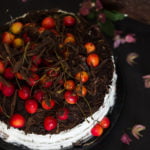 Layered eggless black forest cake with chocolate ganache and cherry decorations