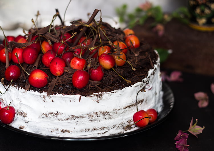 Eggless black forest cake with a side of fresh cherries