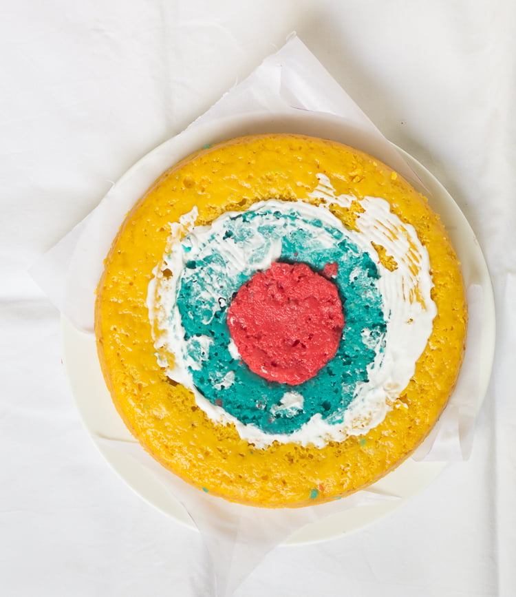 Layers of the Rainbow Checkerboard Cake being assembled