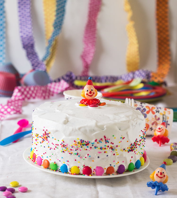 Whole Rainbow Checkerboard Cake topped with creamy white frosting