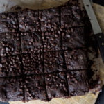A plate of rich, fudgy cucumber brownies topped with the chocolate nuts