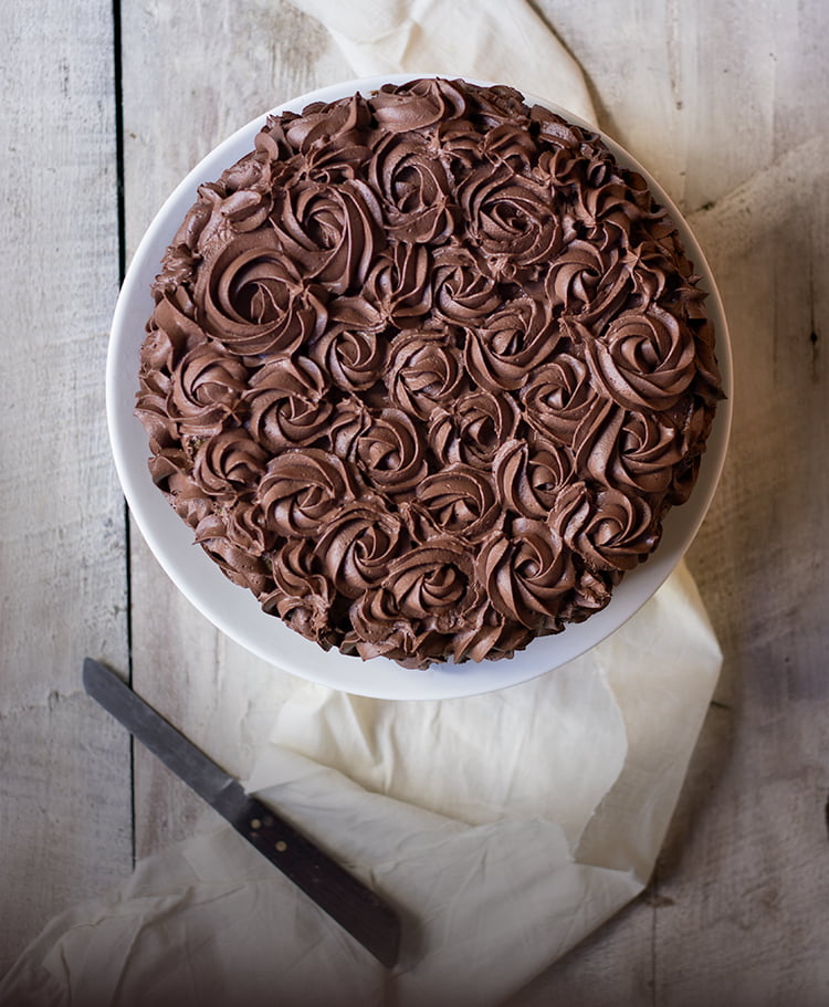 A whole Tiramisu Cake garnished with chocolate curls