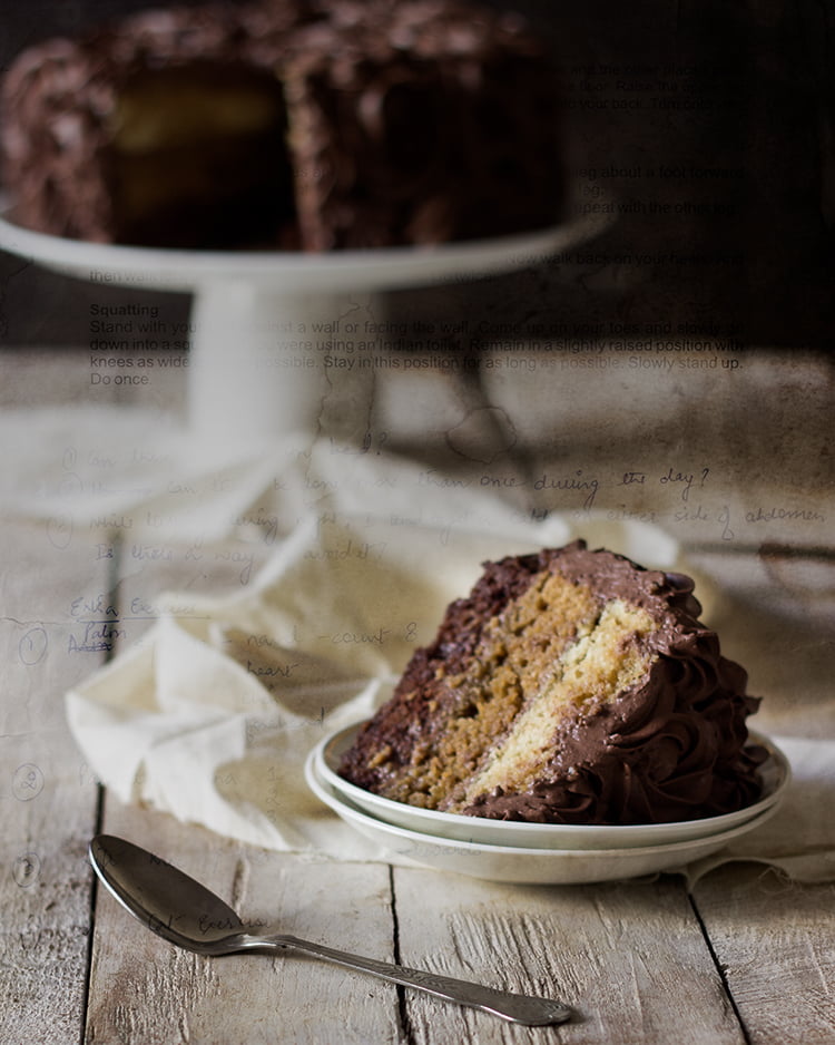 A slice of Tiramisu Chocolate Cake topped with cocoa powder and chocolate shavings