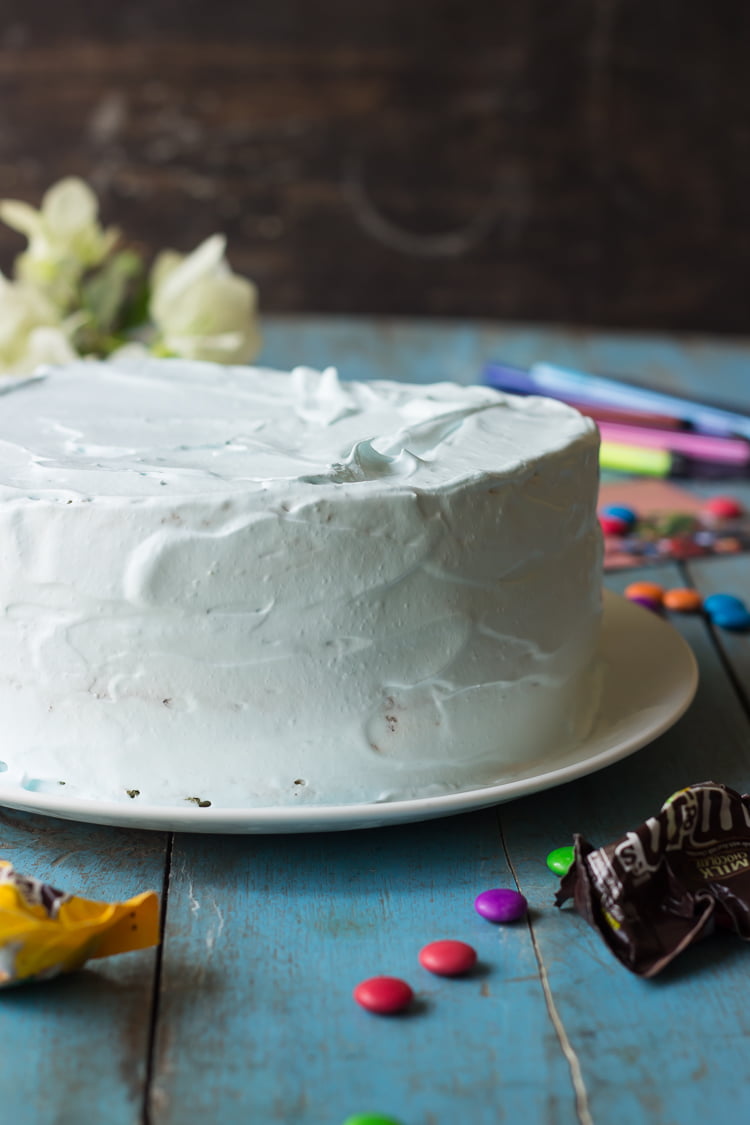 M&M Pinata Cake in making, showing white cream frosting