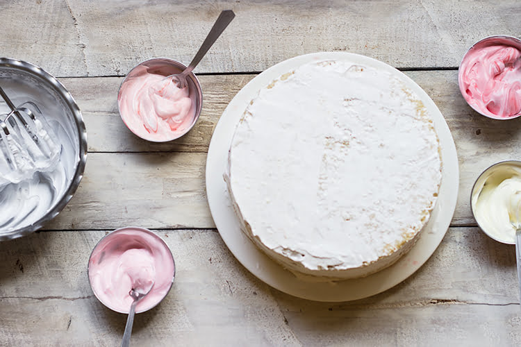 Frosting being applied to the outer layer of the Eggless Strawberry Ombre Cake