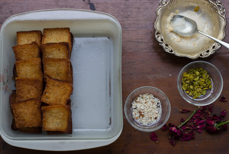 Assembling Shahi Tukda with layers of fried bread, sweetened milk, and nuts