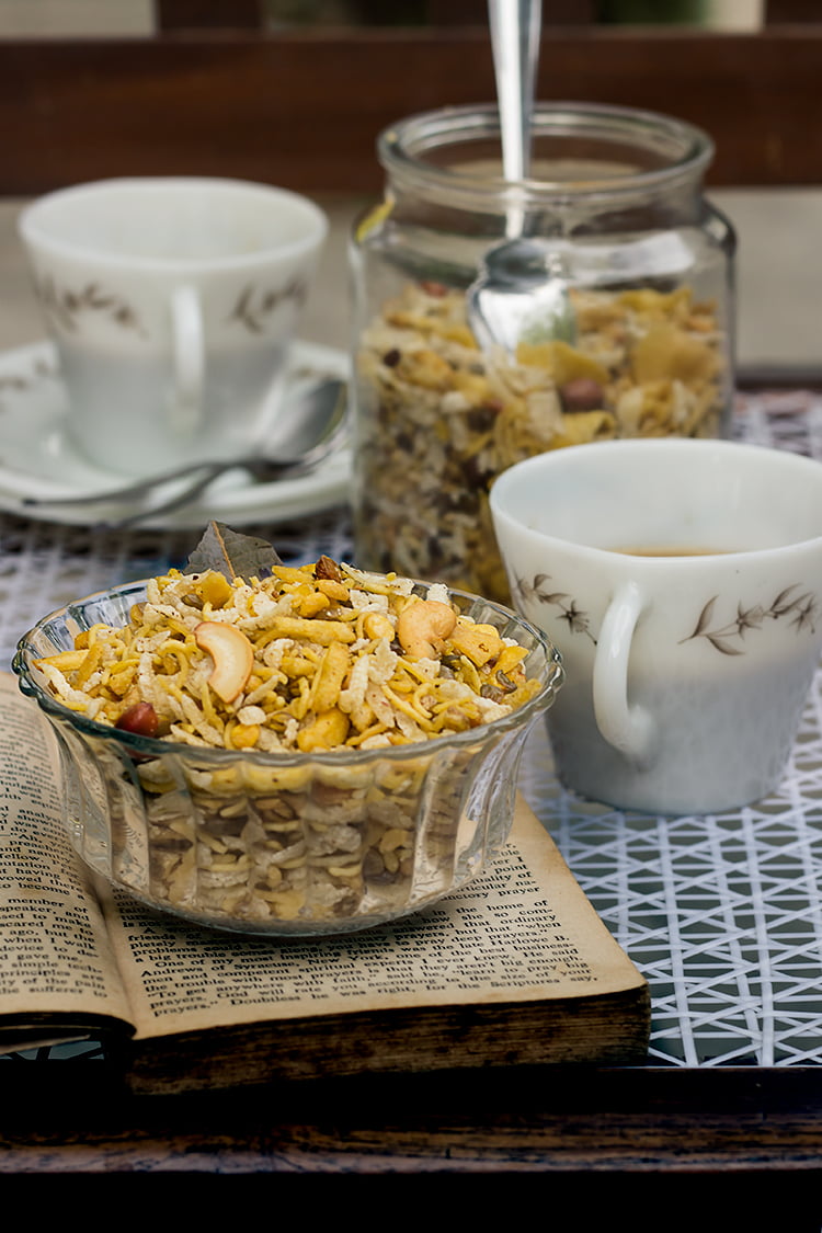 A bowl of spicy chana dal namkeen with a cup of tea at the side