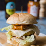 Close-up of a crispy paneer tikka burger with a golden-brown paneer patty