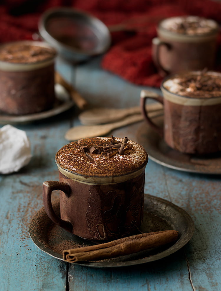 Close-up of a steaming cup of rich homemade hot chocolate topped with whipped cream