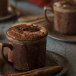 Close-up of a steaming cup of rich homemade hot chocolate topped with whipped cream