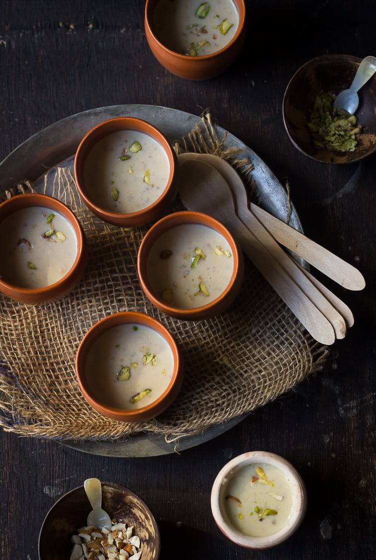 Creamy Bajre ki Kheer in a traditional clay pot topped with sliced almonds and pistachios