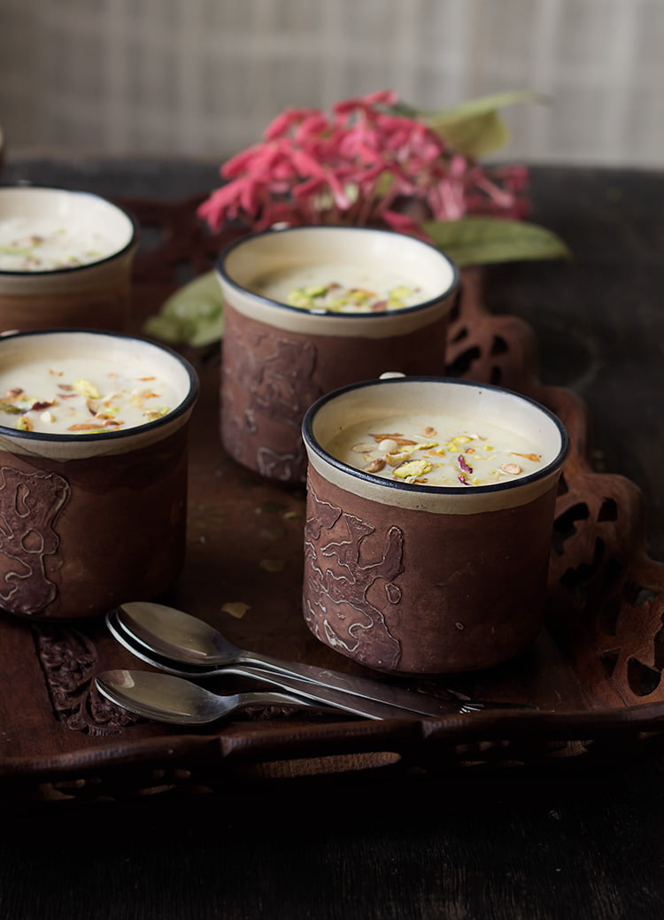 A side view of Jaggery Rice Pudding placed in a tray with spoons 
