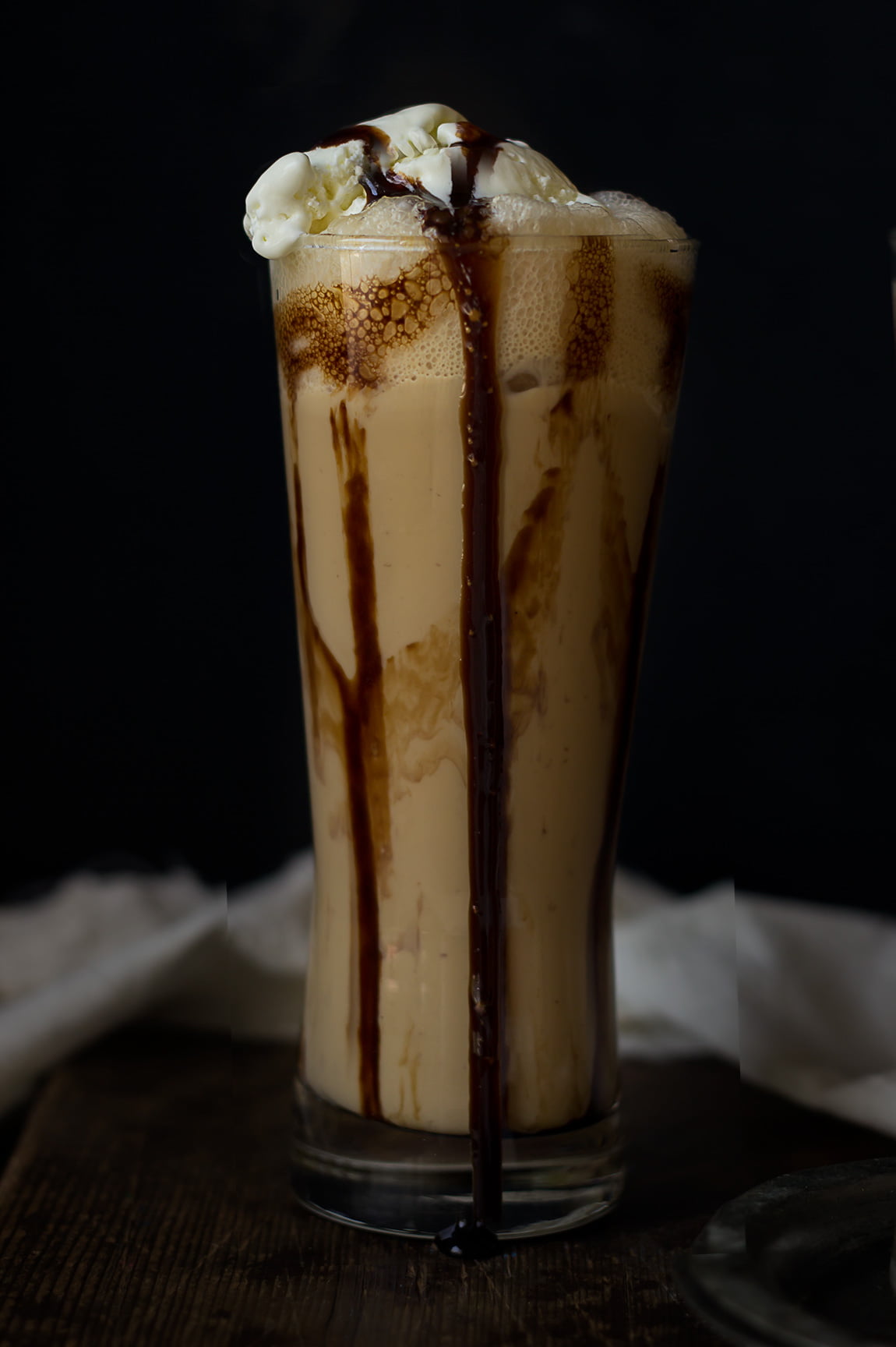 Delicious iced coffee frappe topped with whipped cream and chocolate drizzle