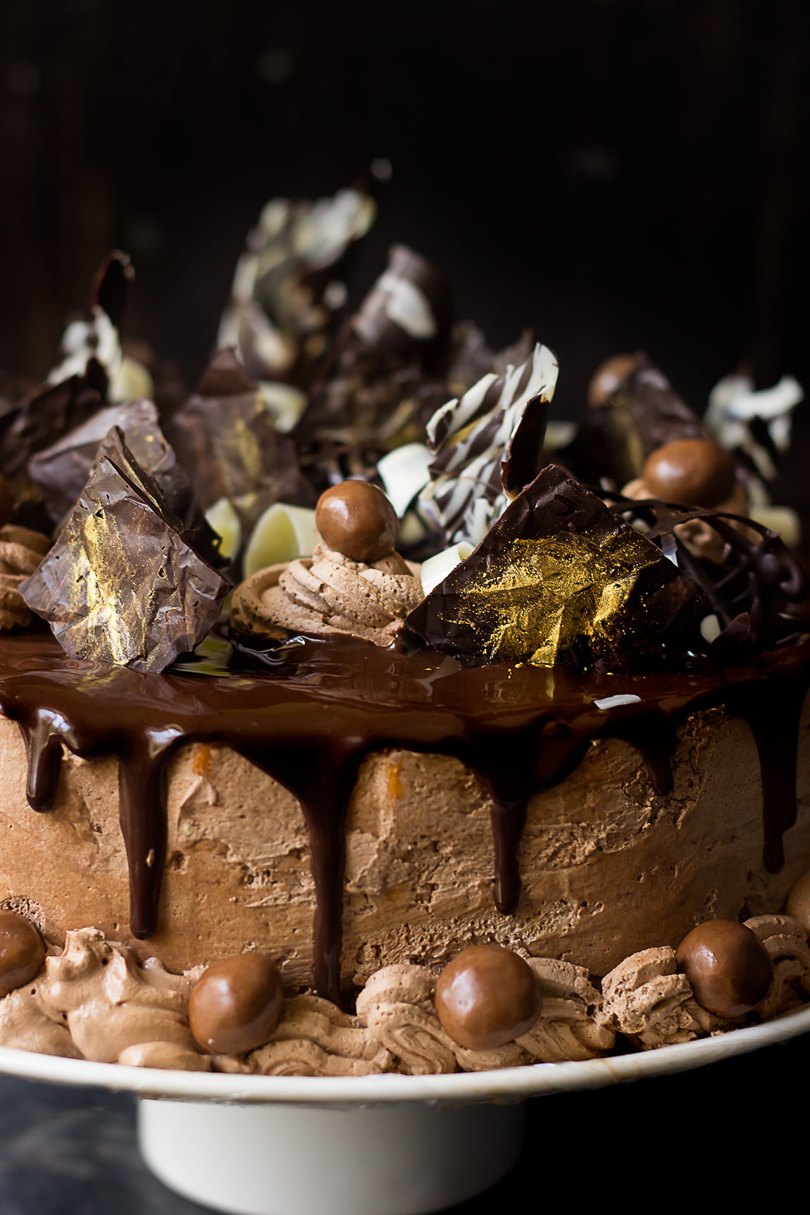 Close-up of garnishing the cake with chocolate shavings and nuts