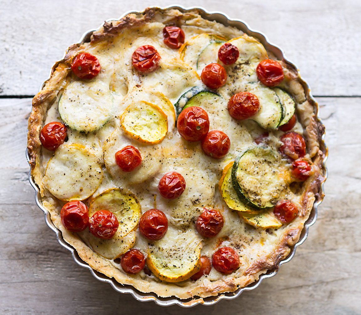 Golden Tomato Zucchini Tart fresh out of the oven, topped with colorful tomatoes and zucchini slices