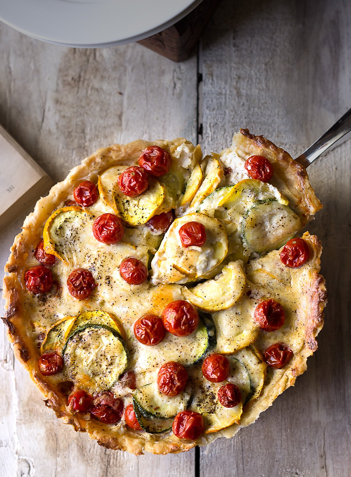 Slicing the Tomato Zucchini Tart into pieces, ready to serve
