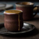 Whisking coffee and sugar mixture in a cup with a spoon