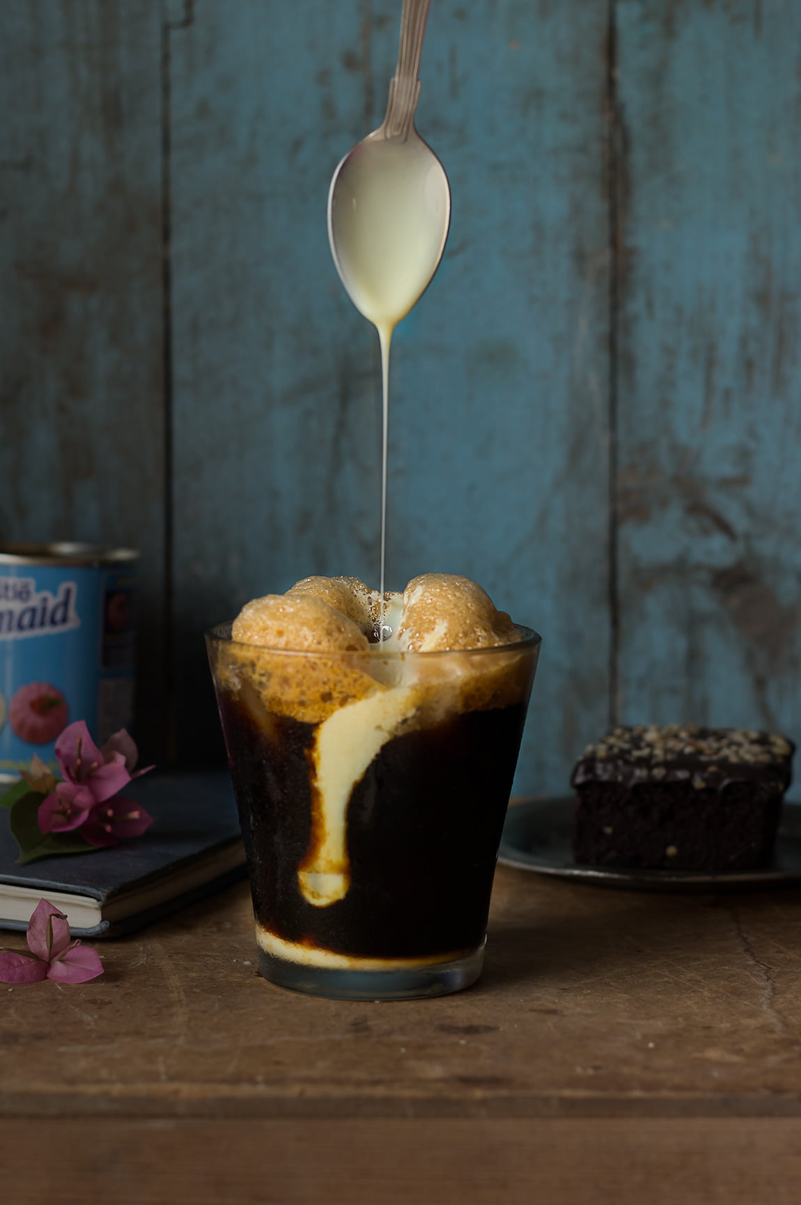 Frothy Greek frappe in a glass, garnished with milkmaid