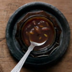 Close-up of Tamarind Chutney drizzling off a spoon, highlighting its thick and smooth texture