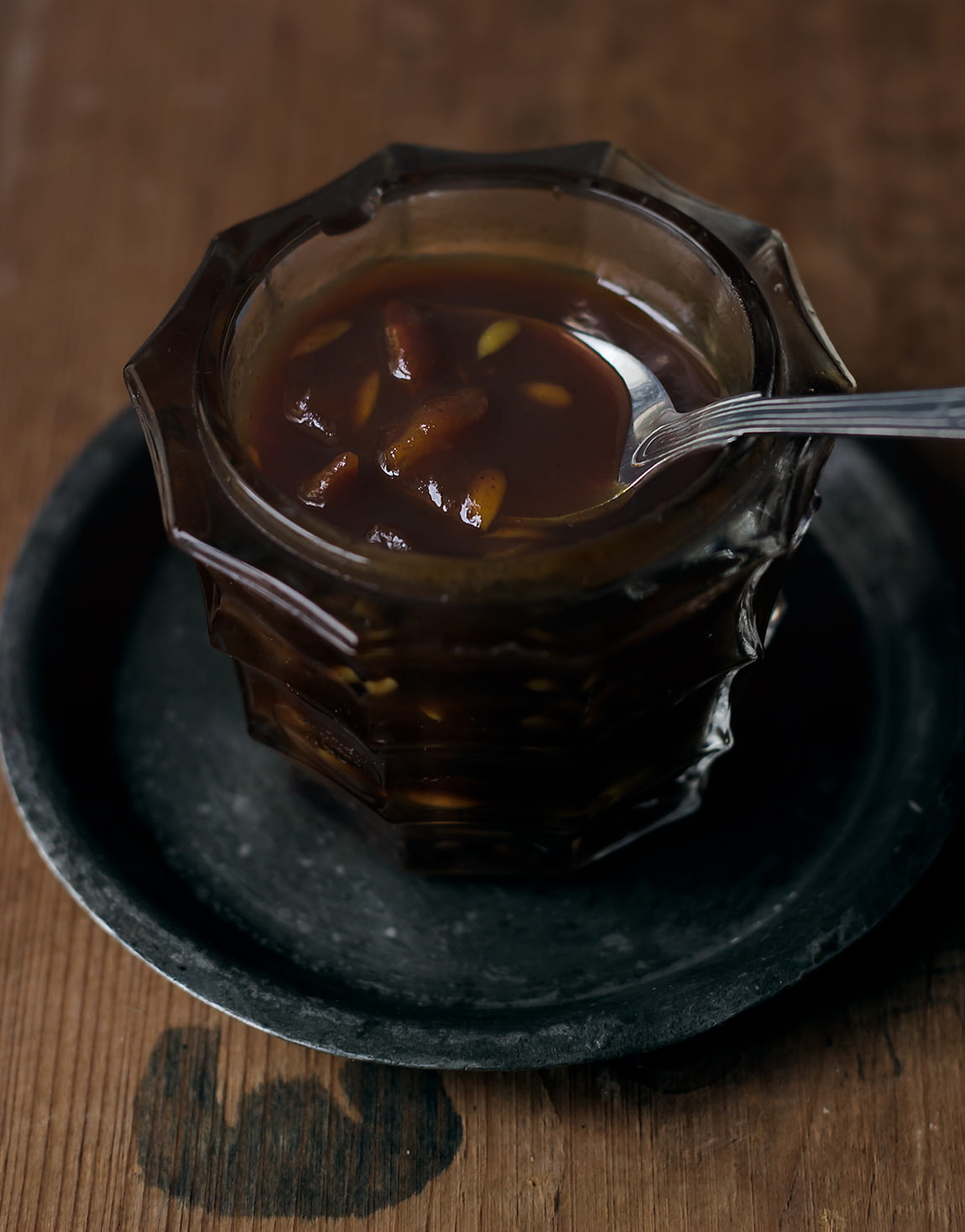 Close-up of Tamarind Chutney drizzling off a spoon, highlighting its thick and smooth texture