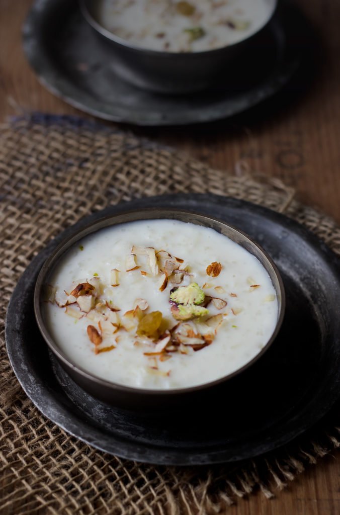 A bowl of creamy rice kheer garnished with almonds and saffron