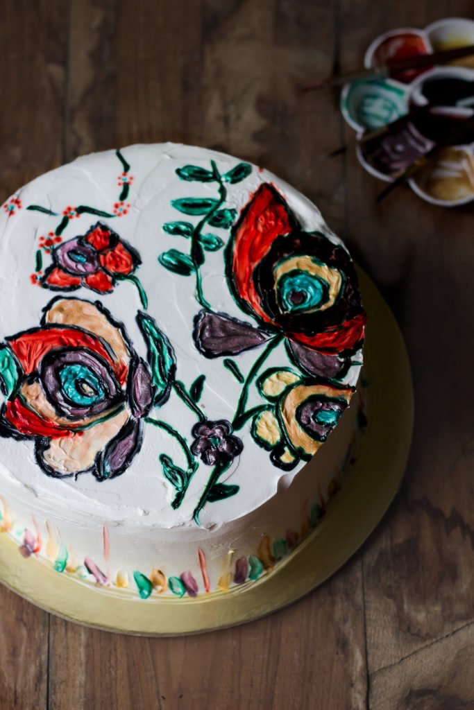 Moist and fluffy eggless hand-painted cake on a plate, highlighting the rich texture and detailed artwork