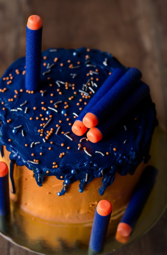 A vibrant and colorful Eggless Nerf Gun Cake decorated with fondant details