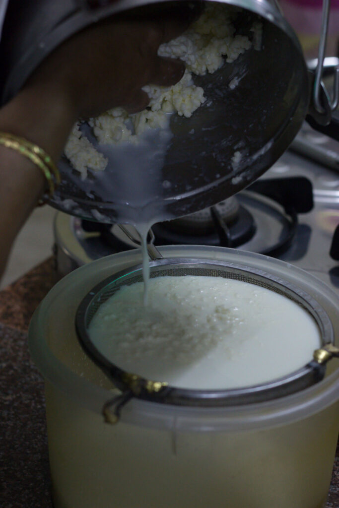 White butter is getting strained from the butter milk