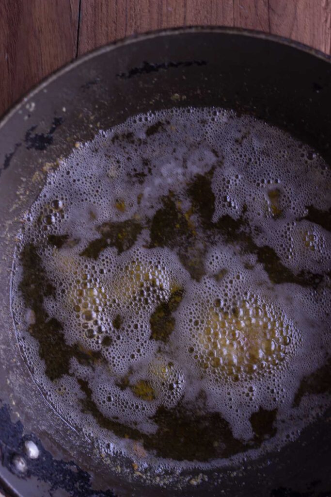 The butter turning a rich golden color as it continues to cook